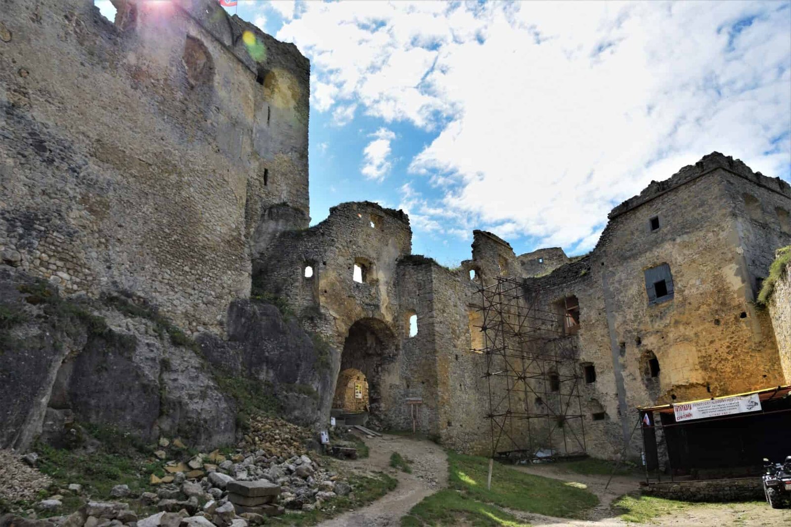 main courtyard of Lietava Castle encircled by high walls of the living quarters; a gate in the middle leads into the castle; there is a small stage in the lower right corner; Slovakia