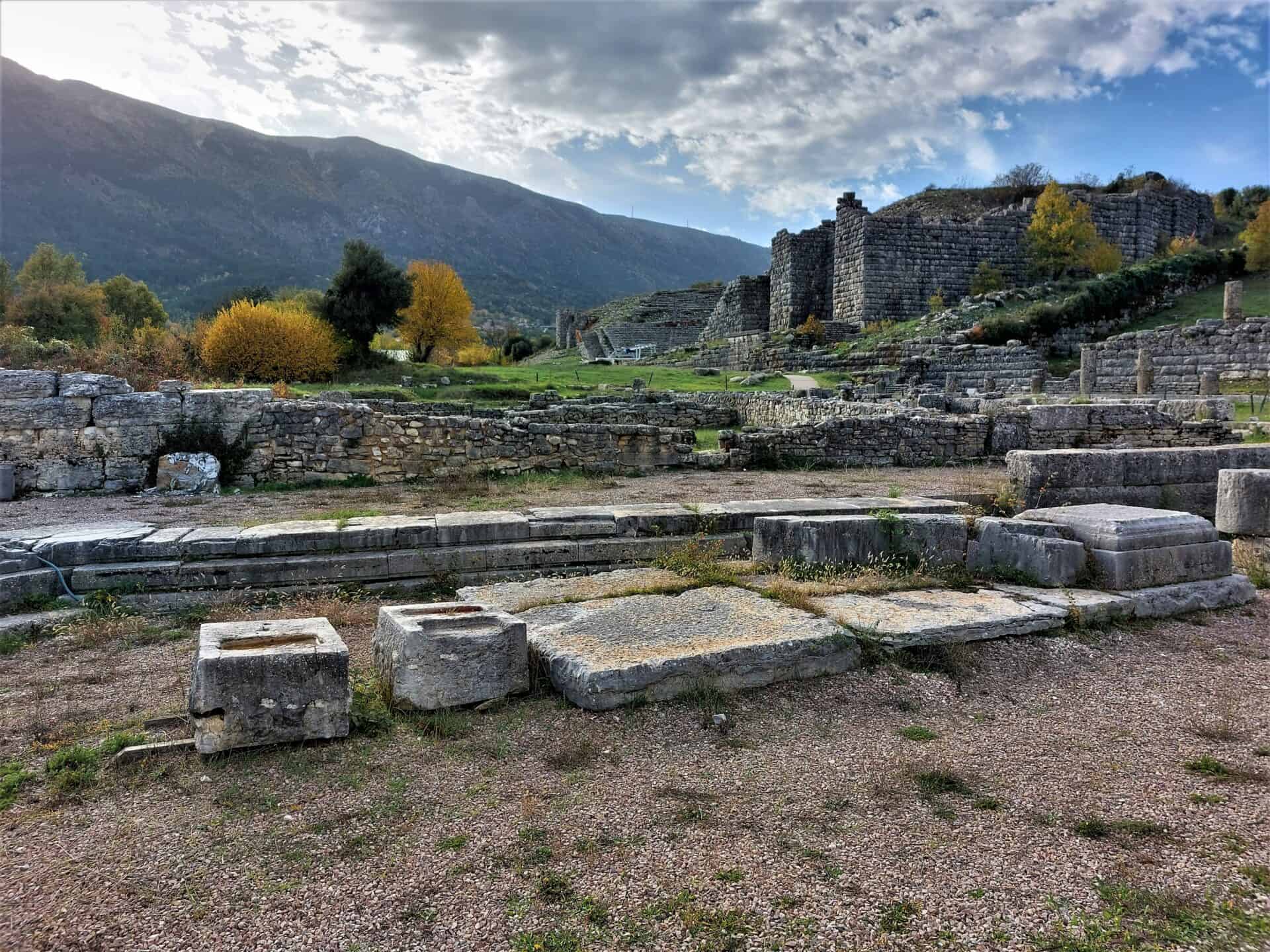 remains of Roman ruins and a massive Greek theatre in front of towering mountains