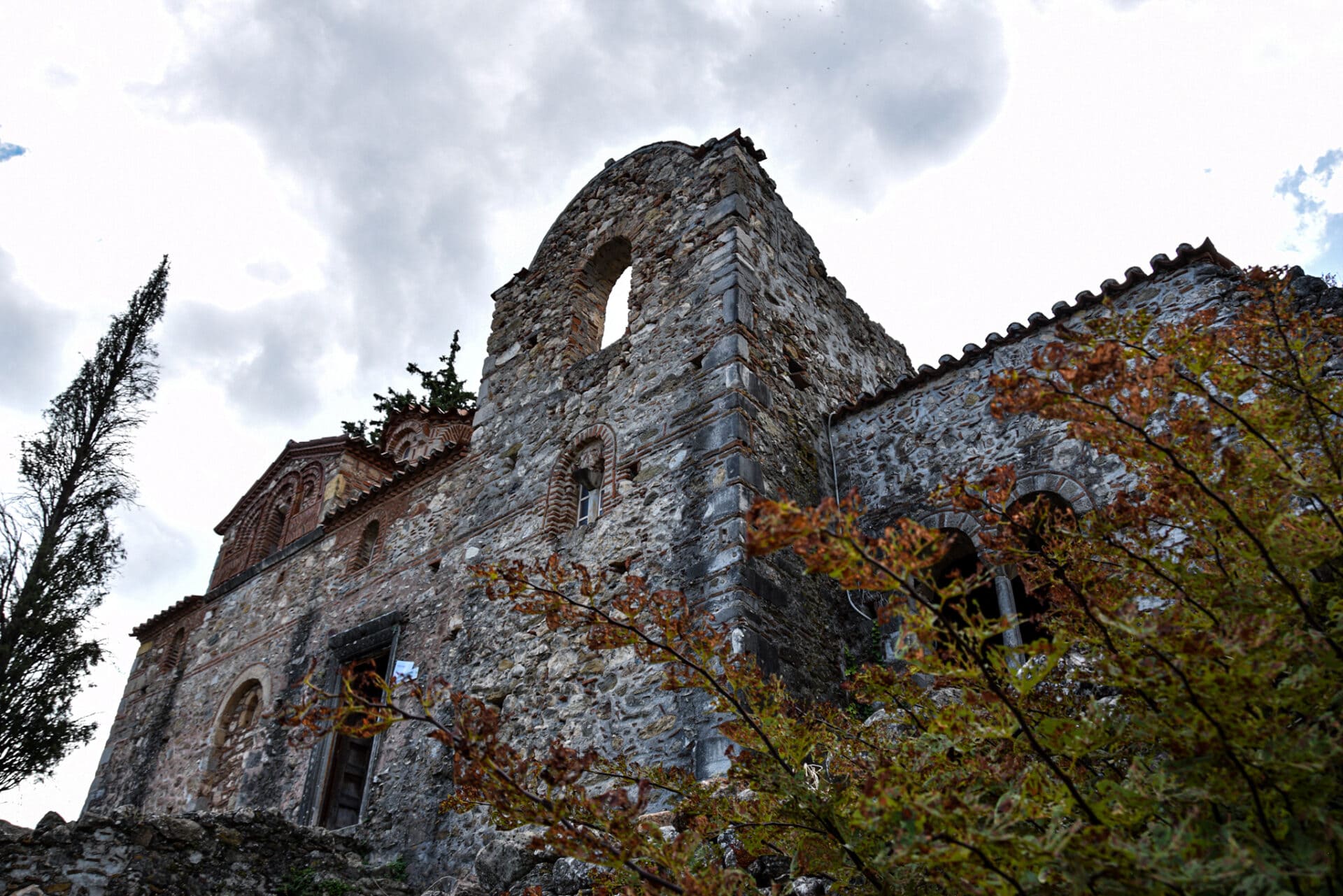 bush with redish leaves in front of a small Byzantine church