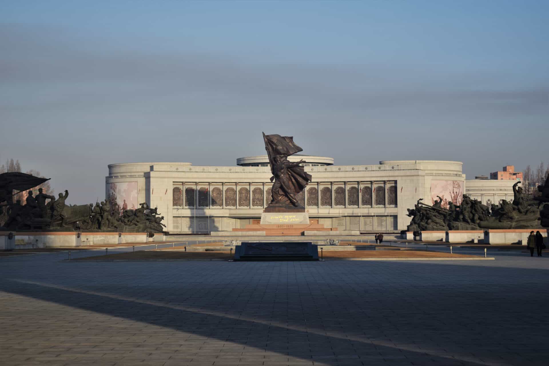 massive statue of a North Korean soldier waving a flag in front of the Victorious War Museum in Pyongyang