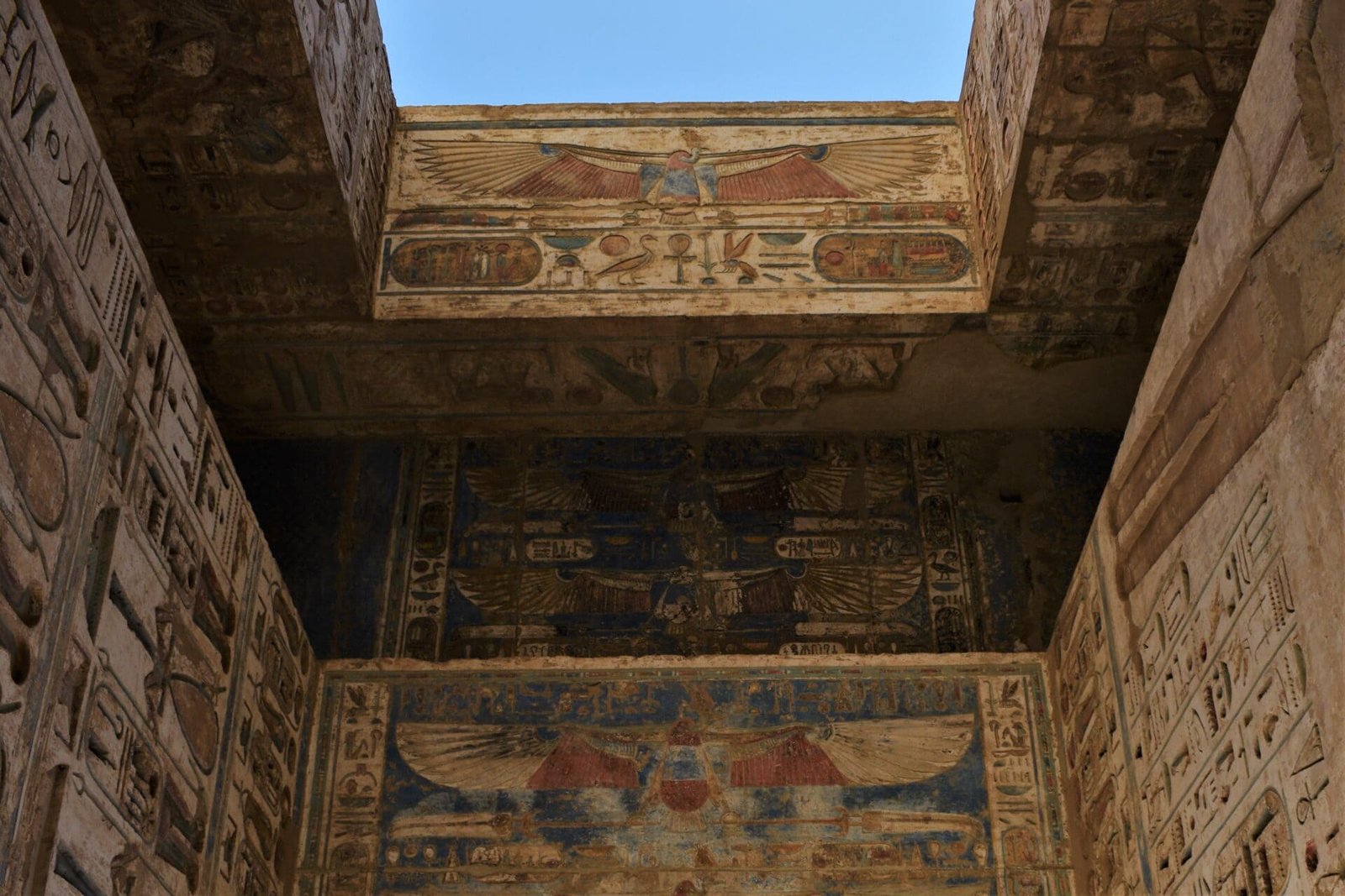 beautiful coloured hiergoglyphes and depictions of vultures adorne the ceiling of an ancient temple