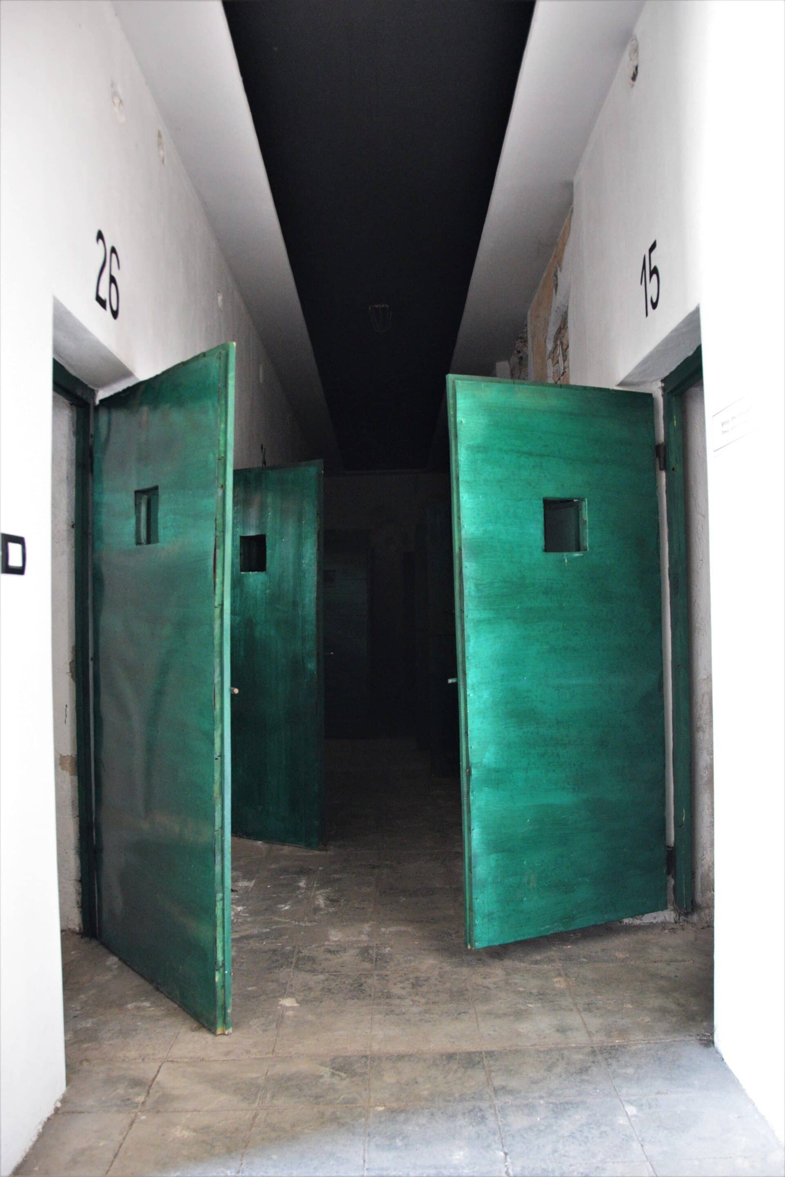 open cell doors in a hallway of a former prison
