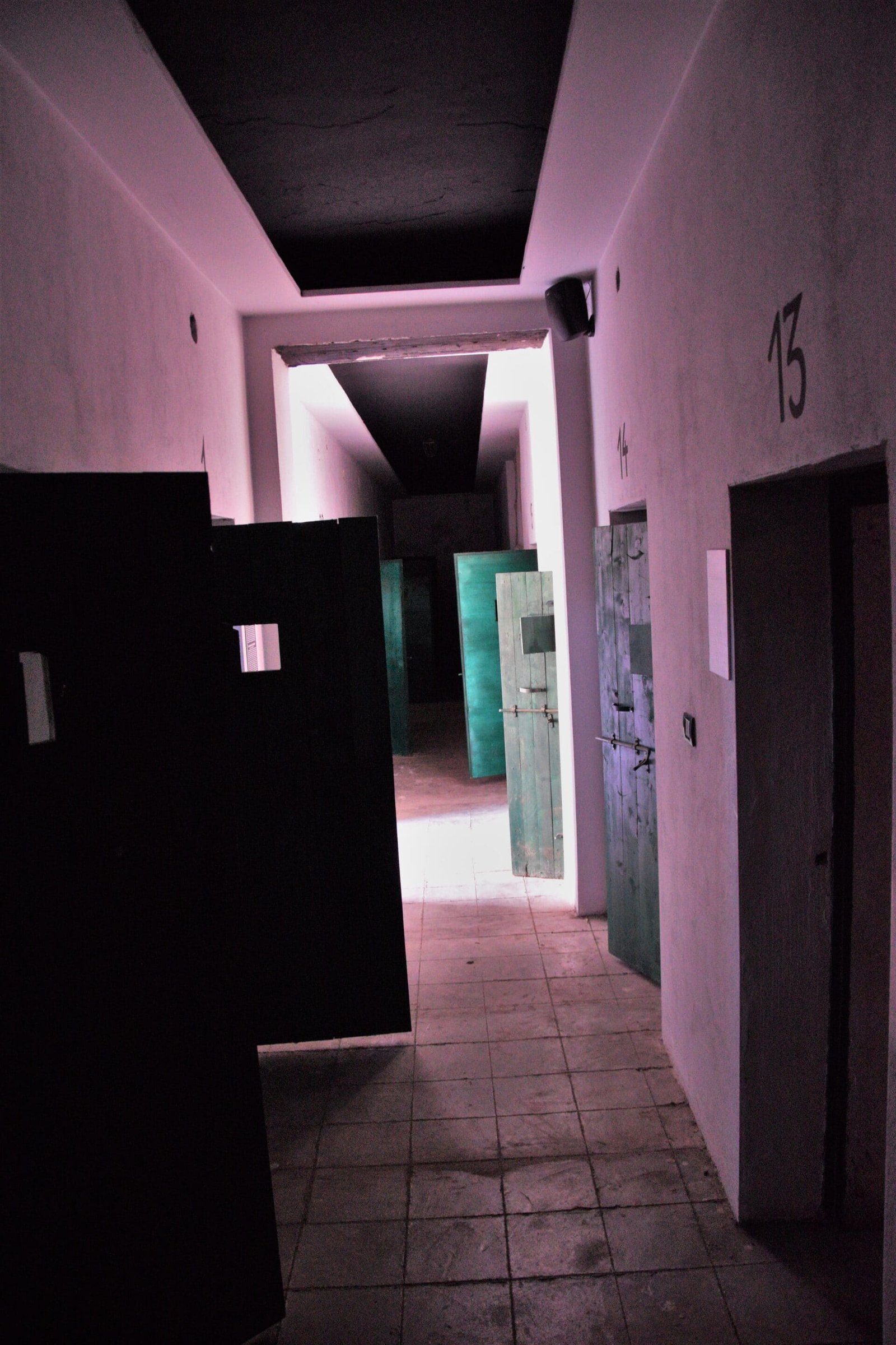 open cell doors in a hallway of a former prison