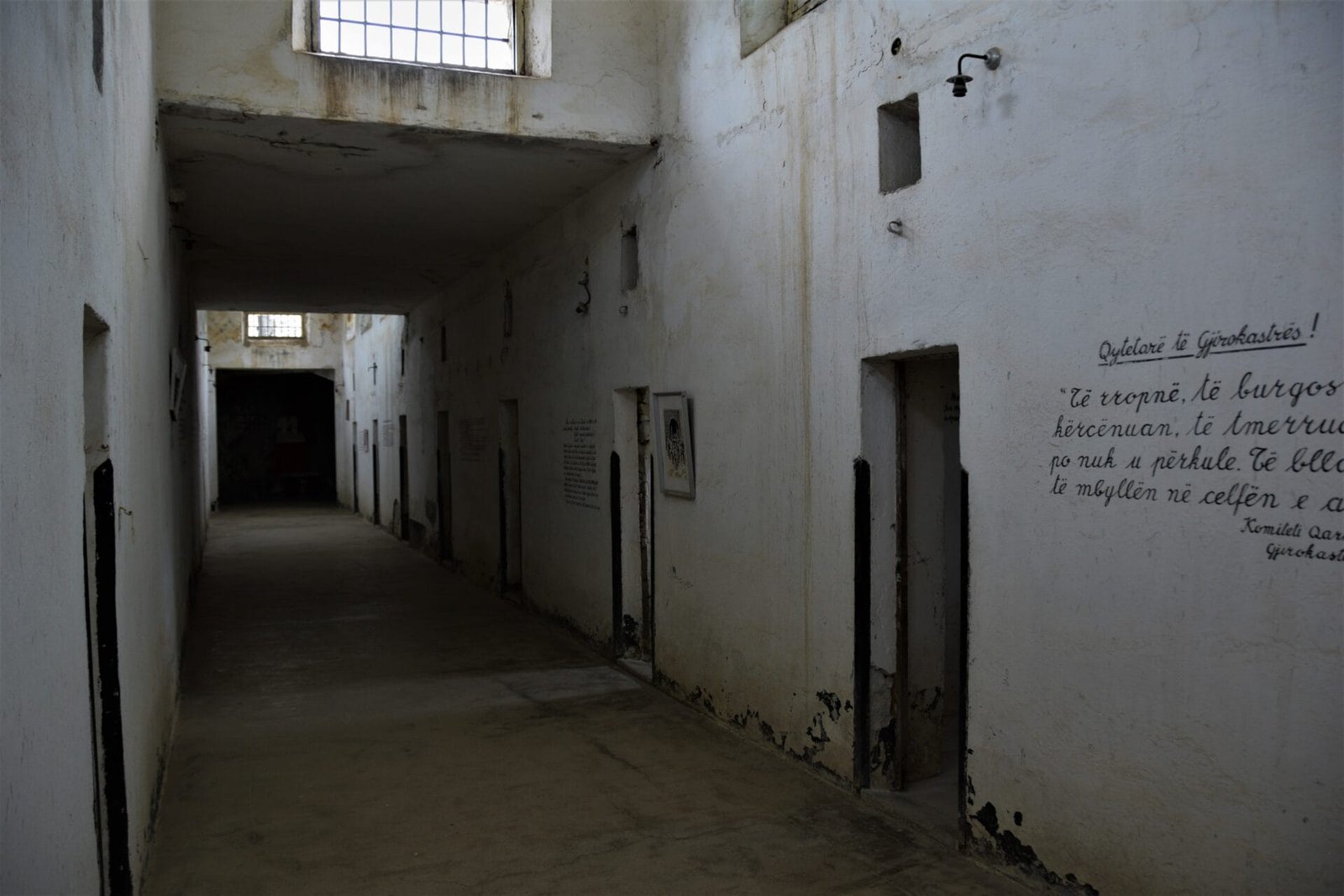 writings on a wall in a hallway of a former prison