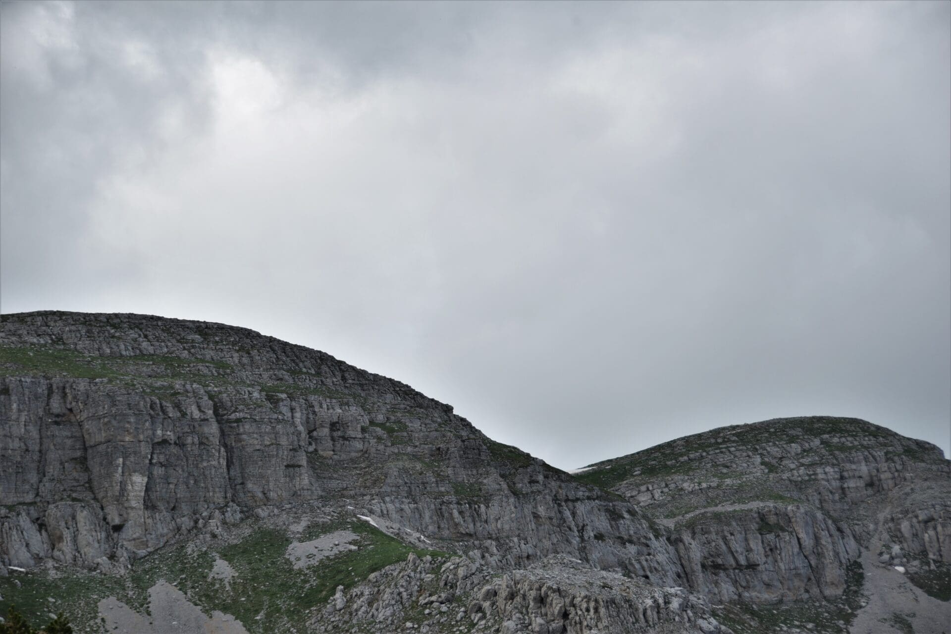 grey clouds loom over a rocky ridge