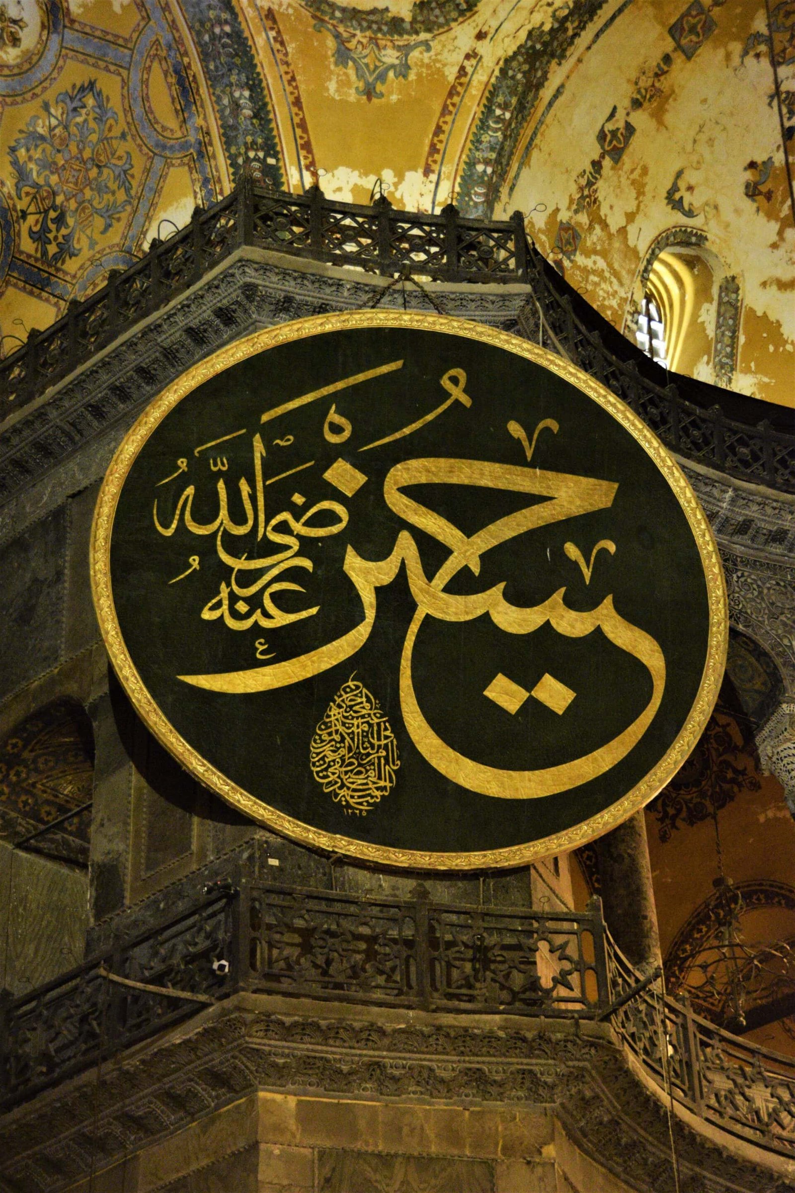 giant, wodden disc depicting the name of Hussain in golden calligraphy