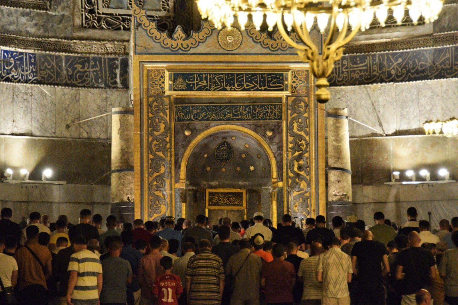 muslims gather in front of the mihrab for prayer in the Hagia Sophia