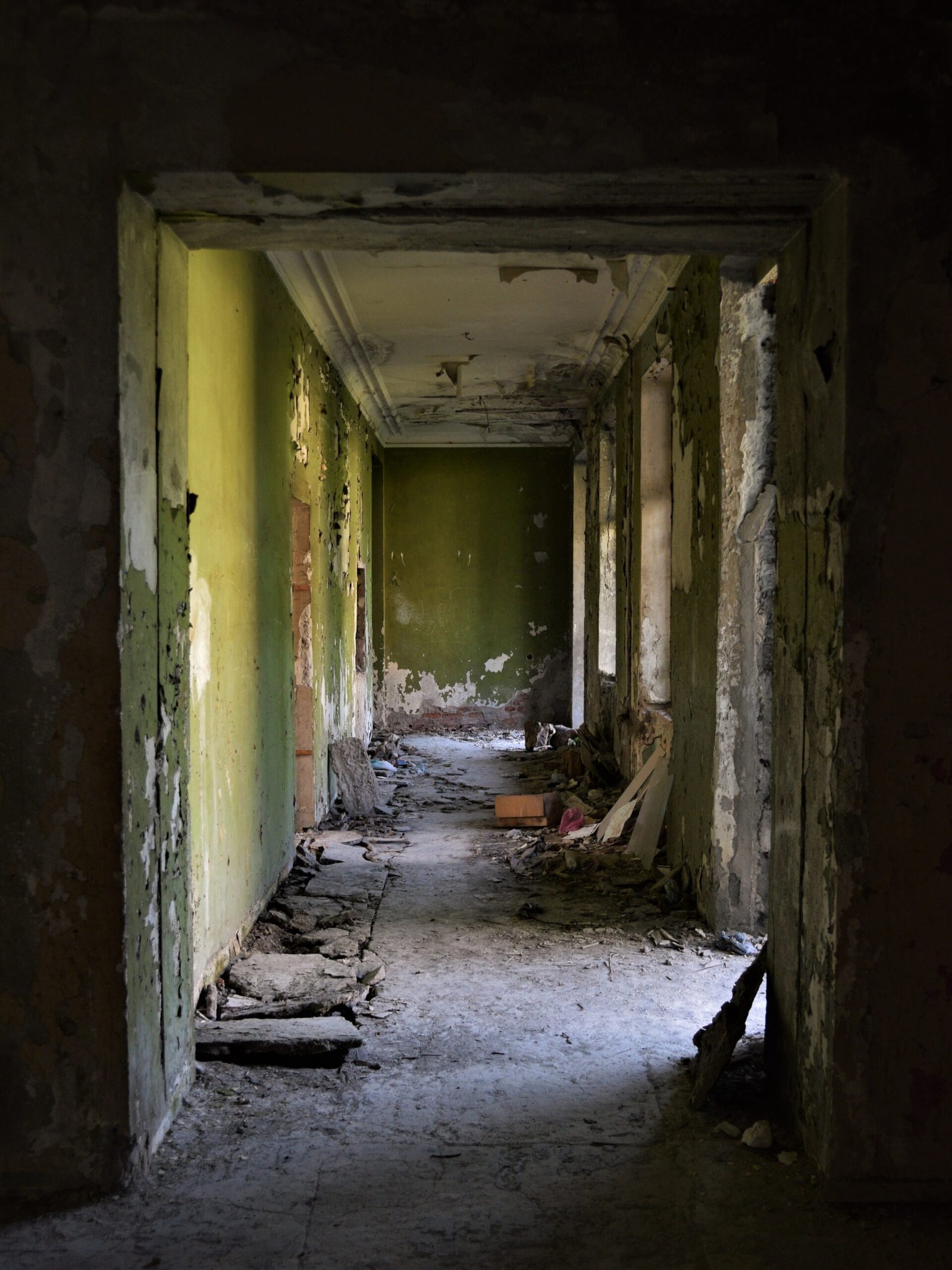 a derelict hallway painted green in an abandoned Soviet sanatorium