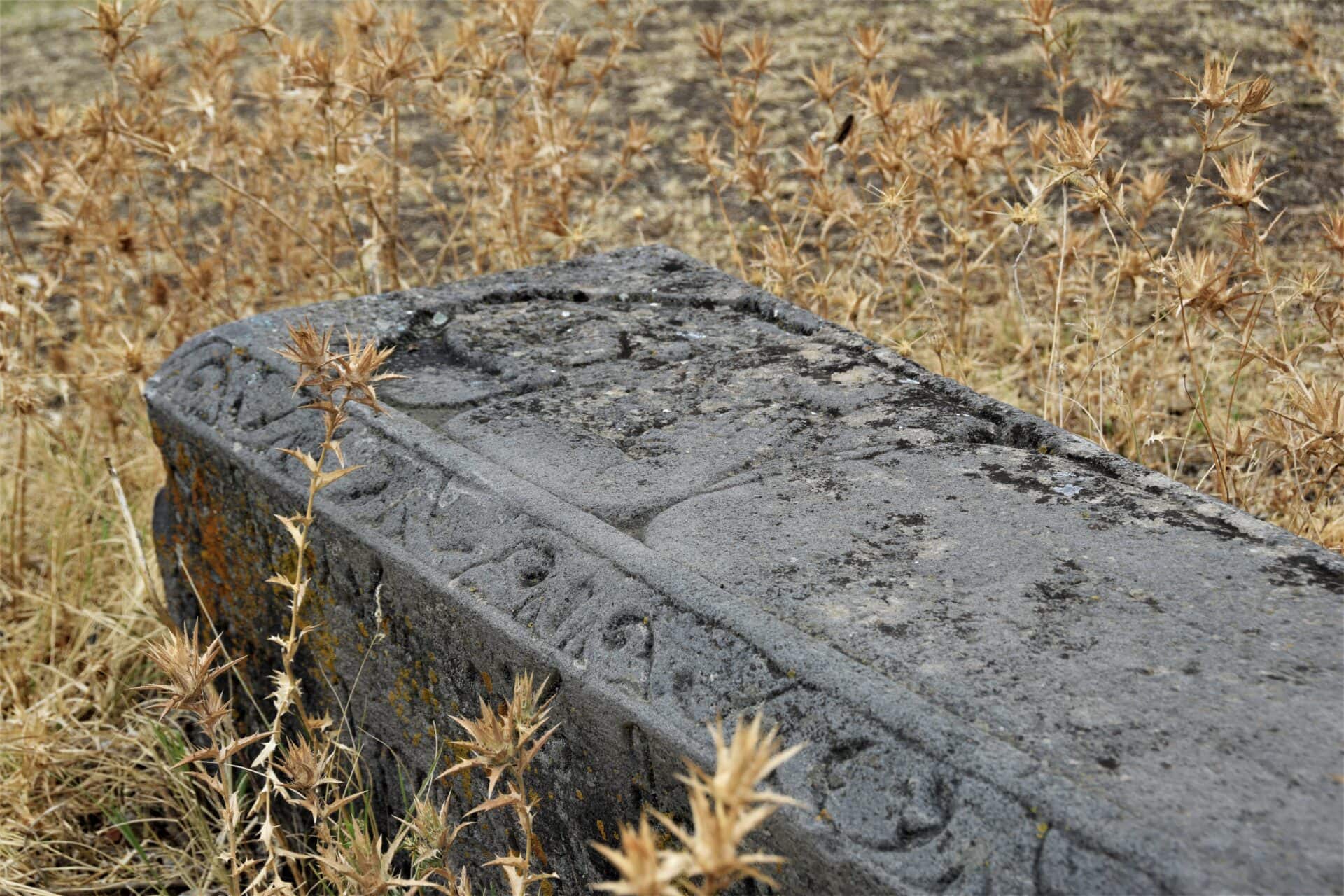 a Medieval Georgian tomb stone surrounded by dry grass