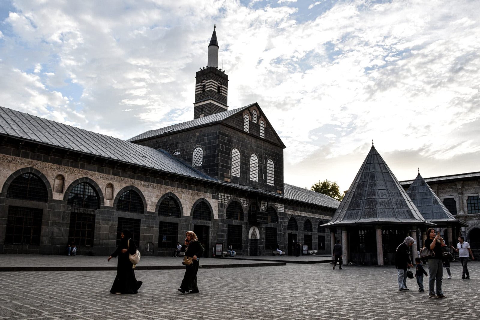 two women walk across the main square of Diyarbakir Great Mosque