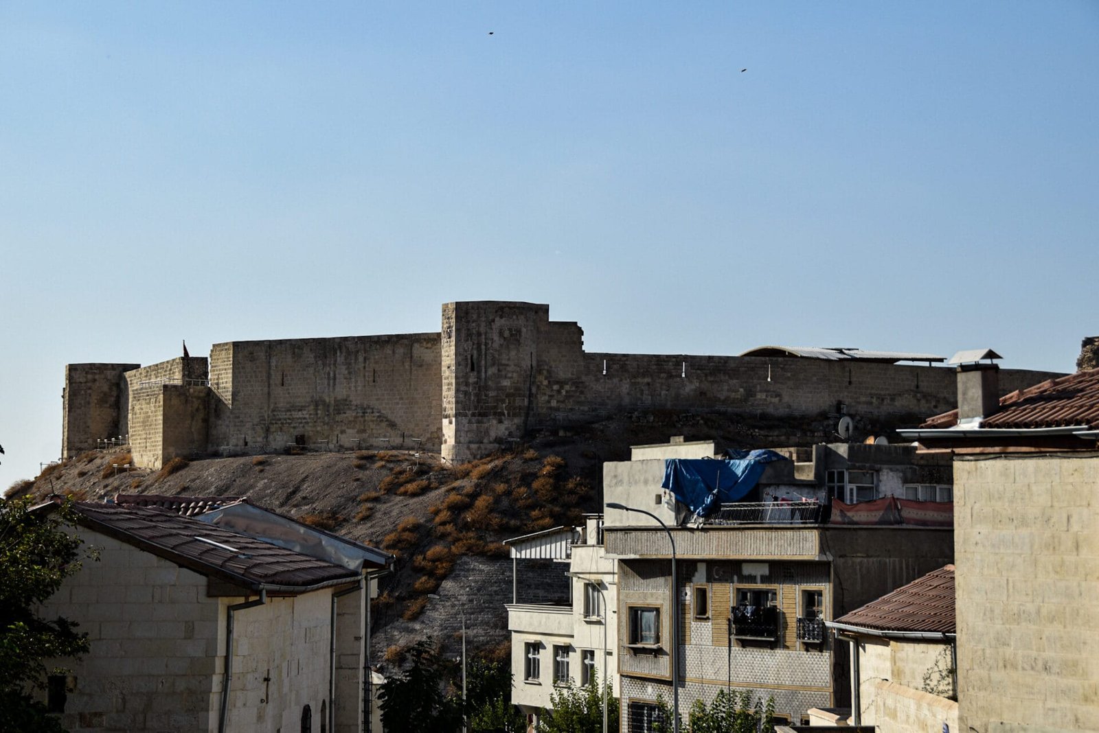 the ramparts of Gazaintep castle rise above the roofs of the old town