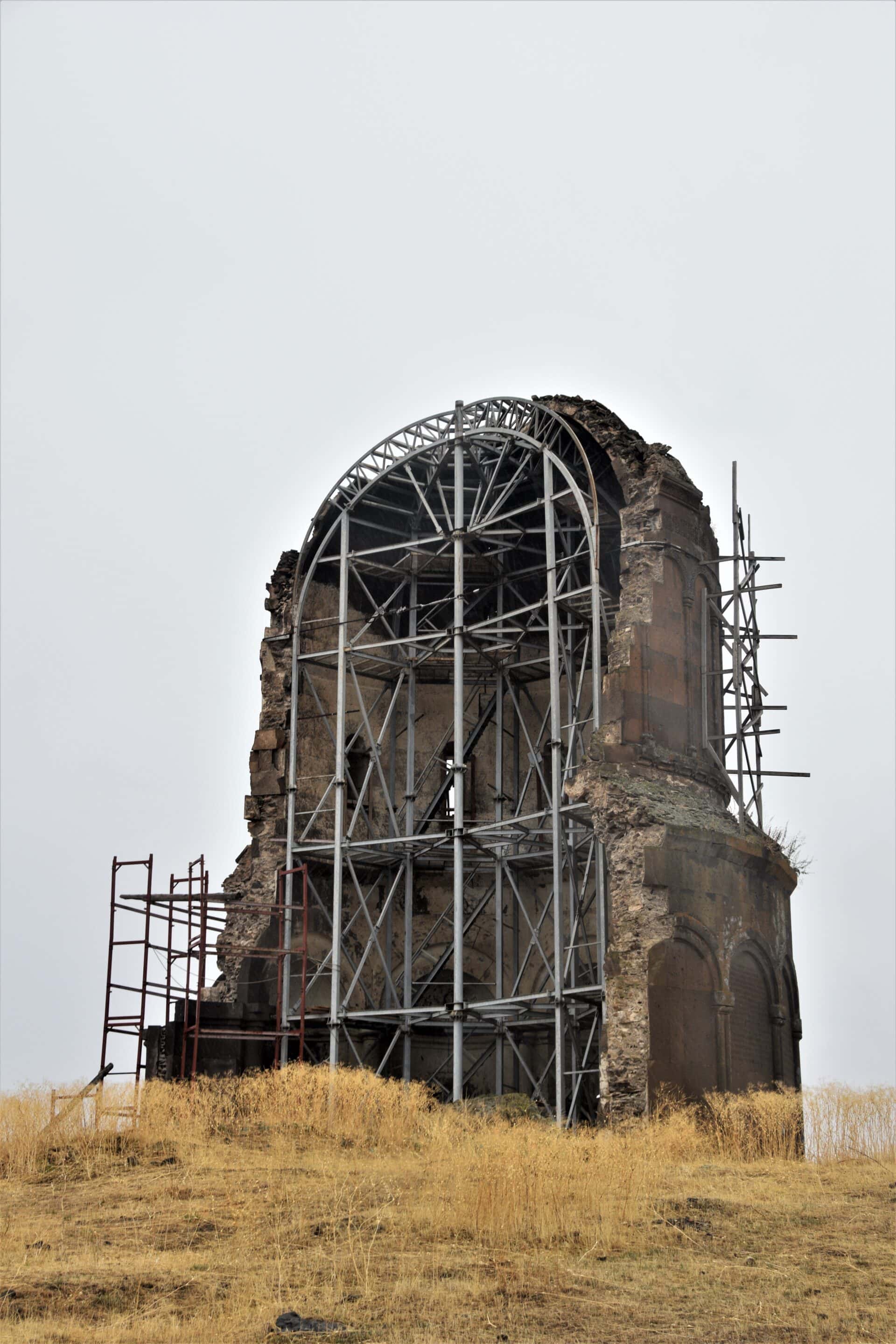 the remaining half of an Armenian church held up by scafolding