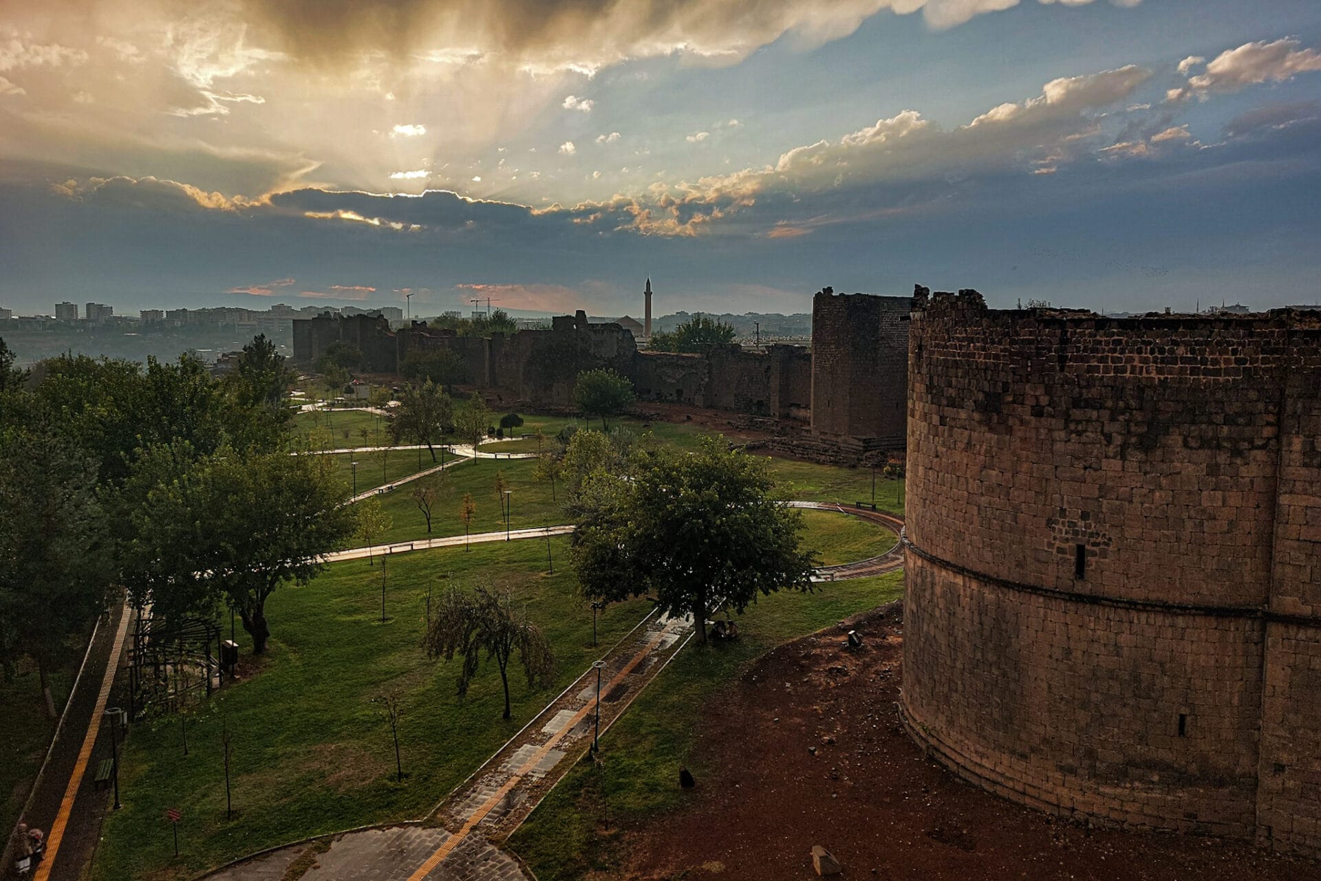 the sun breaks through the clouds above the impressive city walls of Diyarbakir