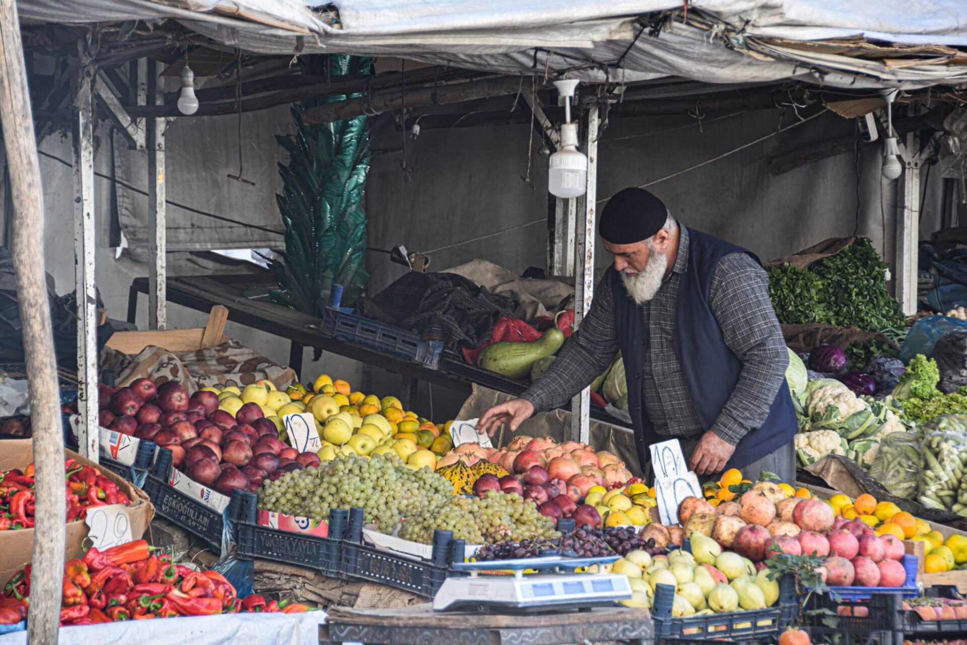 a vendor rearranges his fruits on a markt in Sanliurfa