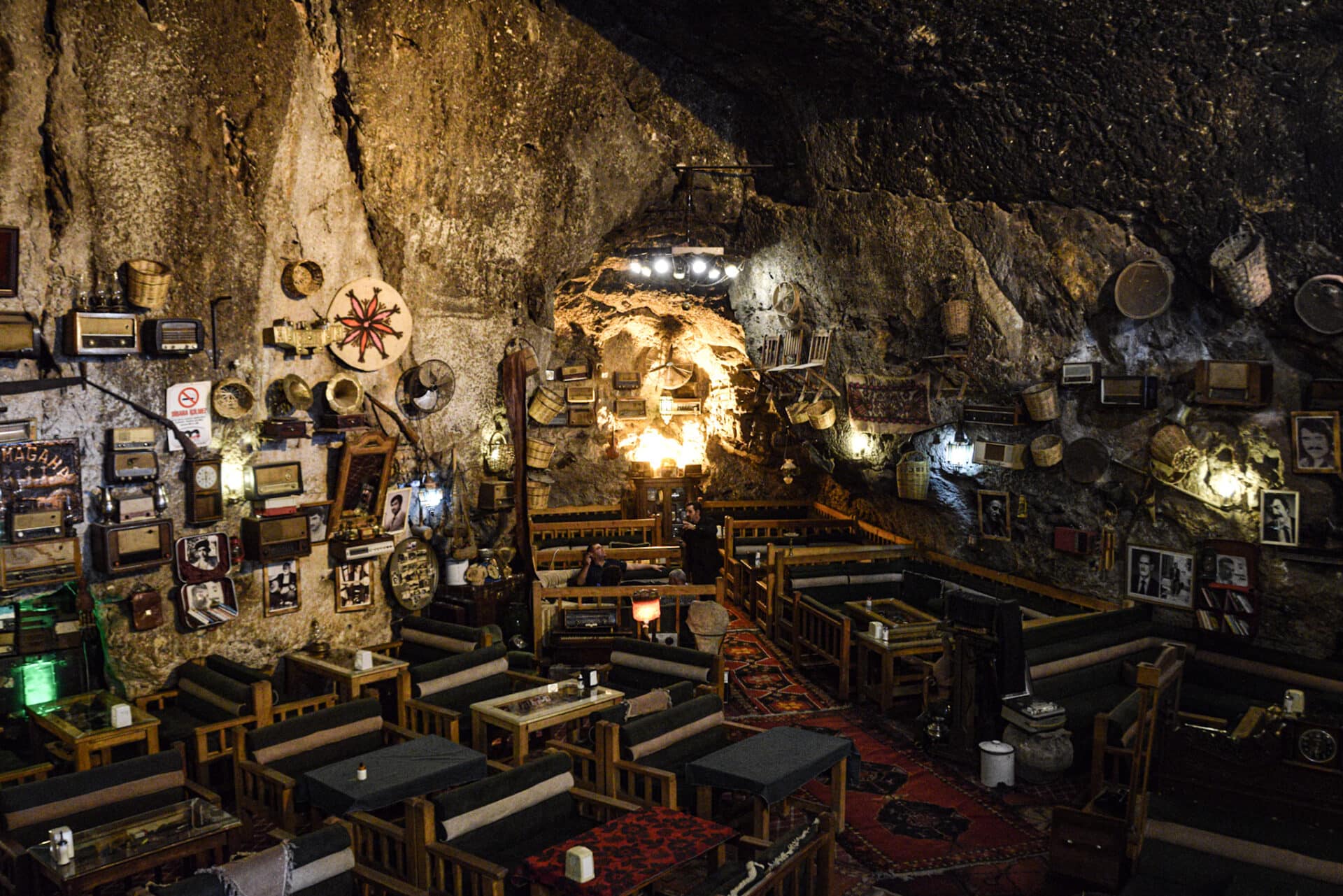 the main room of a peculiar cave café decorated with various antique items