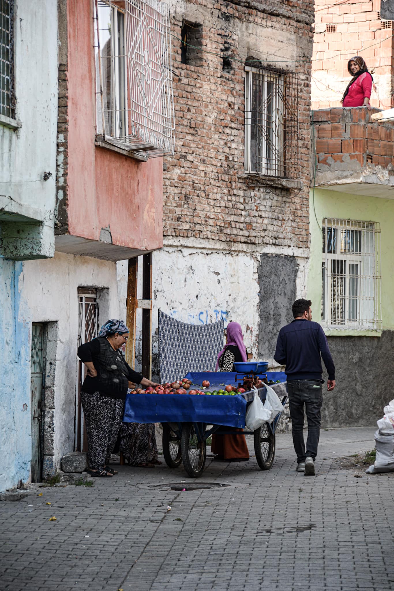 a man selling fruits from a blue cart in a sidealley in Diyarbakir old town