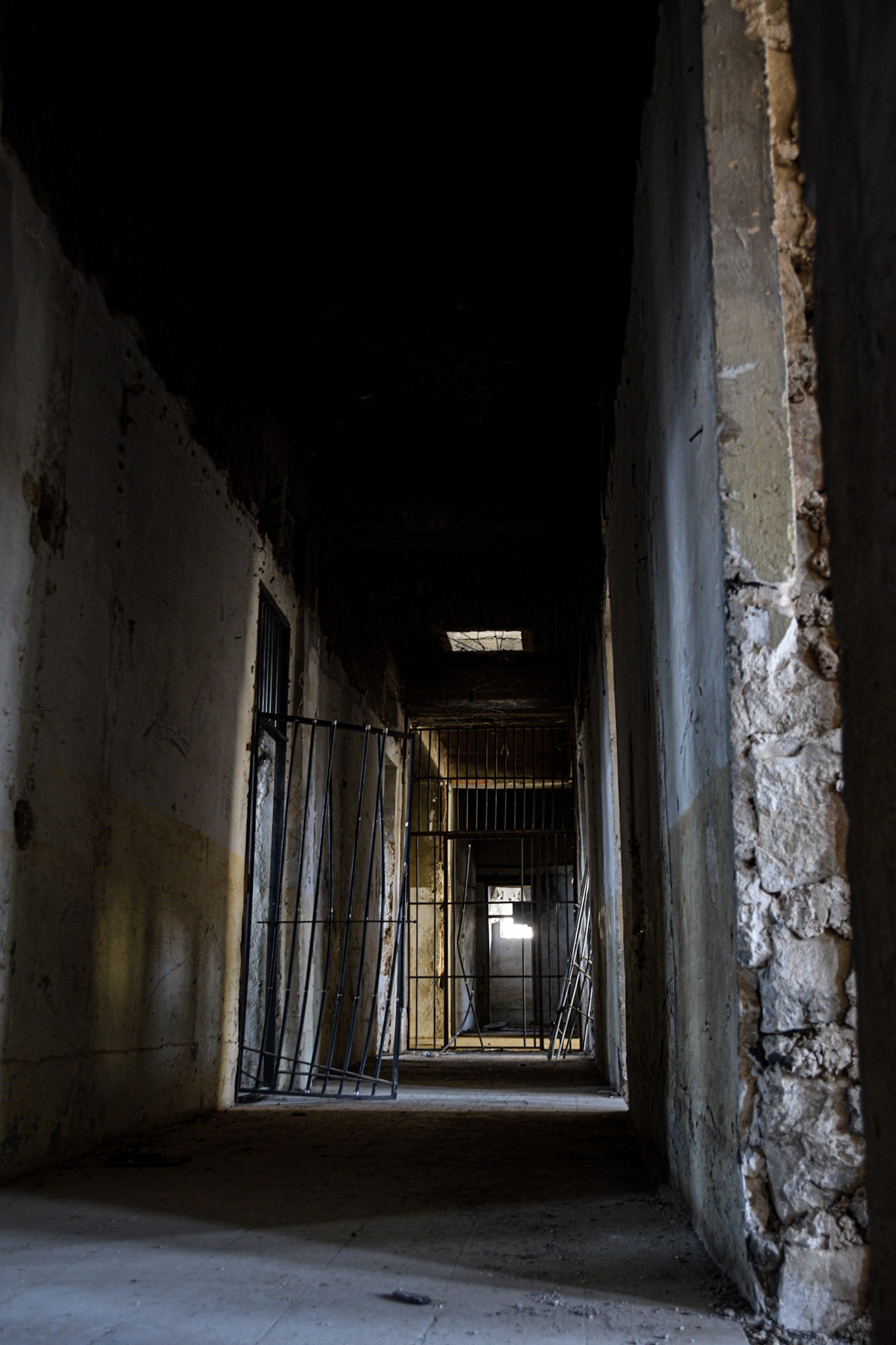 a dim hallway in a cell block of an abandoned prison