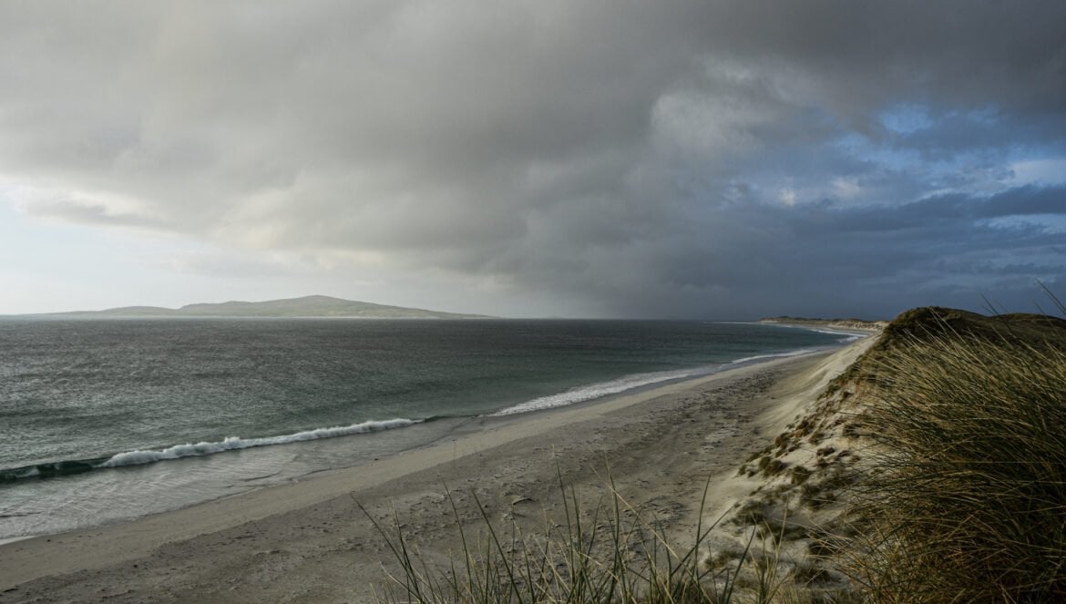 dark clouds gather over a sandy beach on the island of Berneray