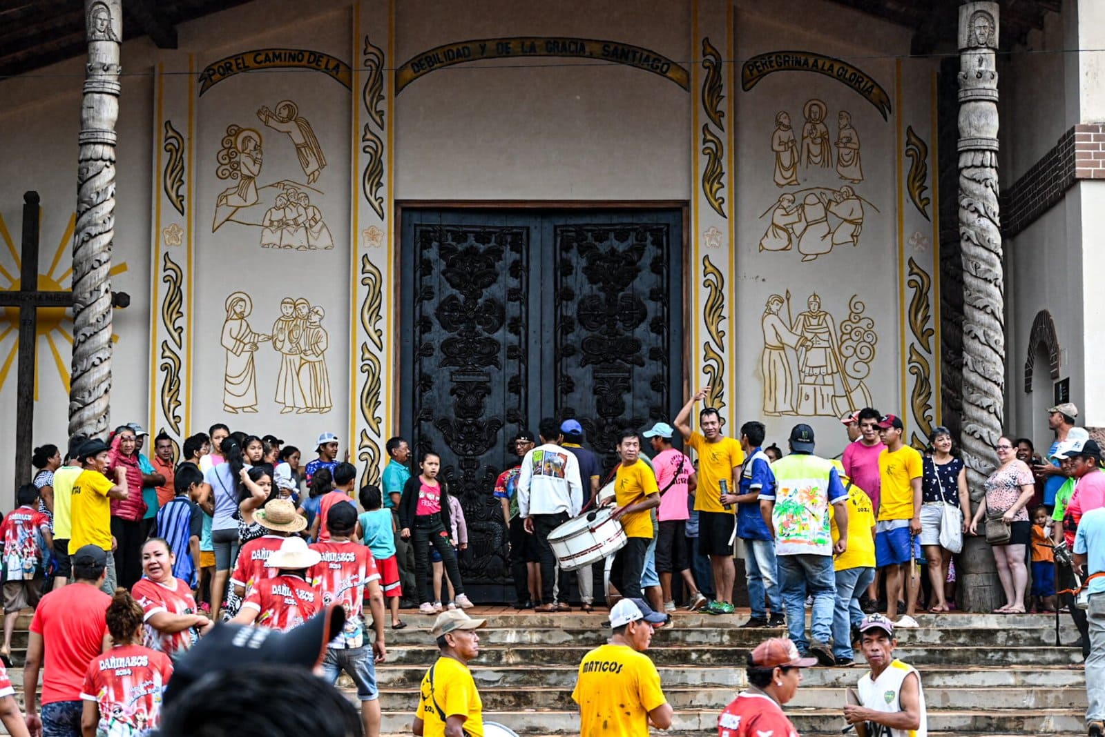 people stand on the steps of the Jesuit church in Santiago de Chiquitos during carnival