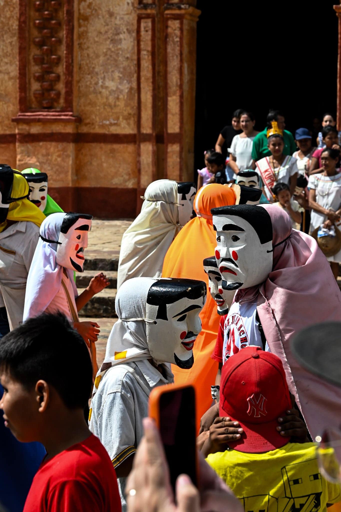 men dressed as the "abuelos", folkloric figures from chiquitano culture, gather in front of a Jesuit church in San José de Chiquitos