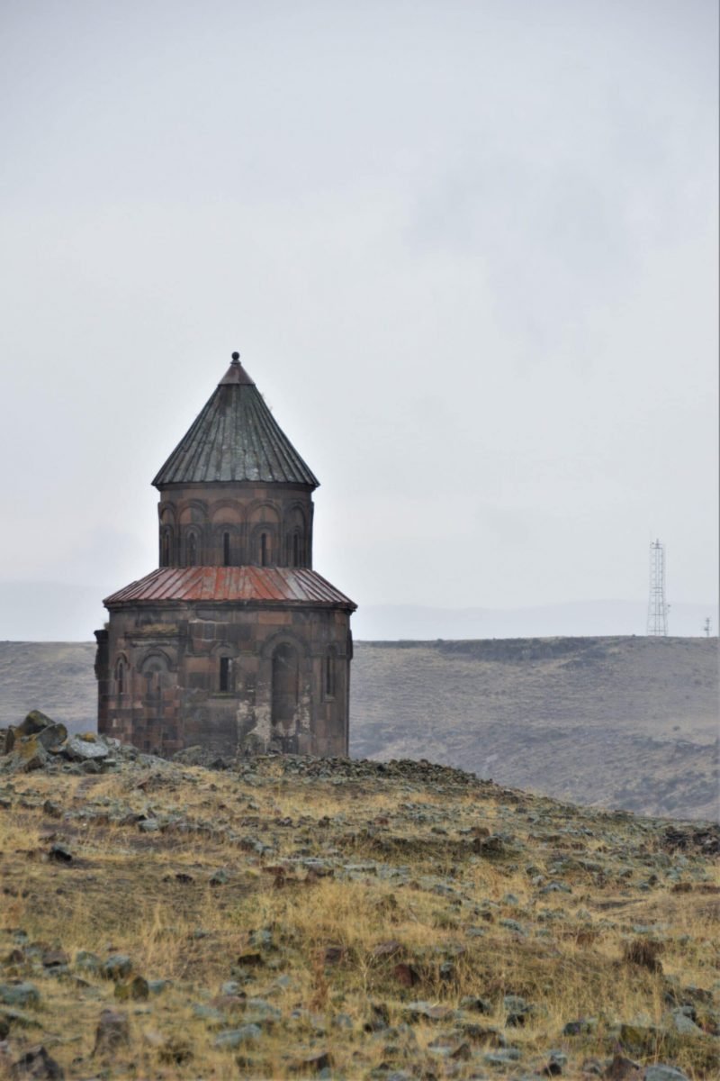 an Armenian church stands on a field in the ancient city of Ani