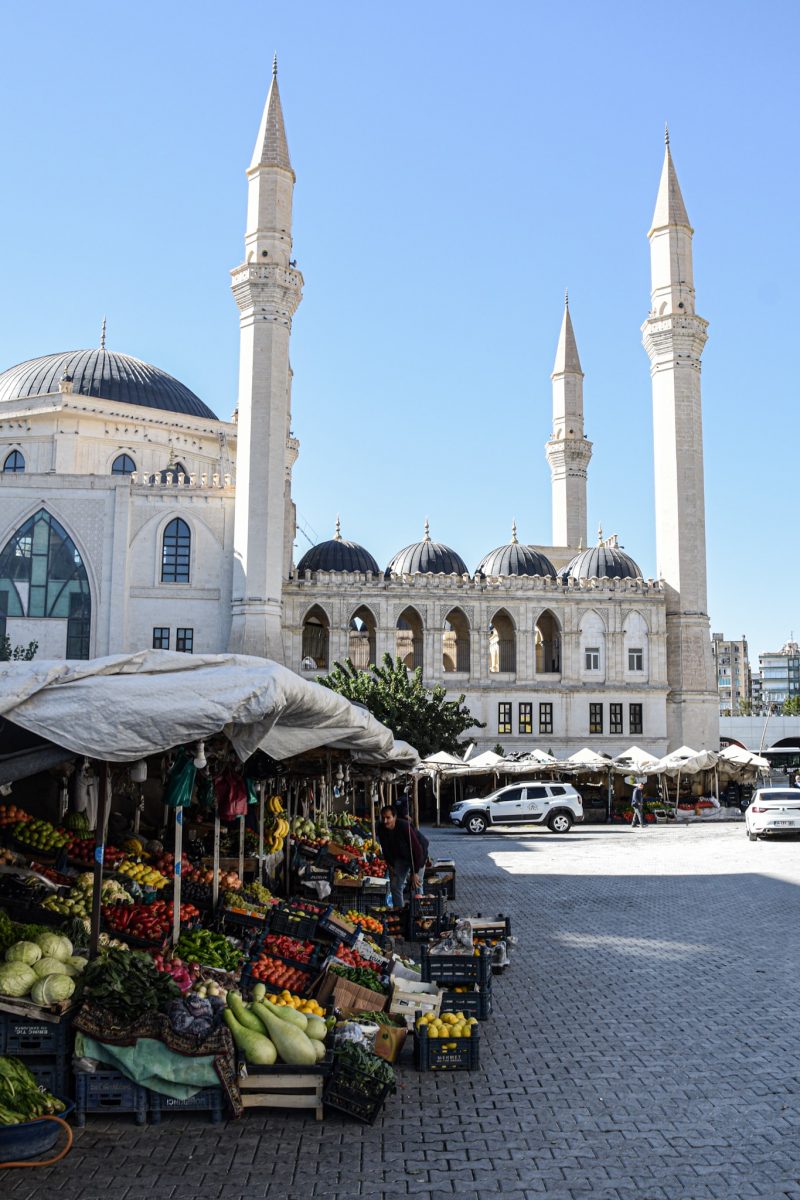 fruit stands in front of a huge mosque built from white marble